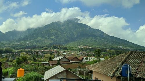 Scenic view of townscape and mountains against sky