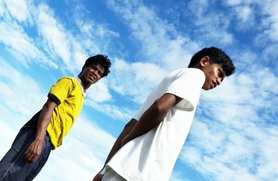 Low angle view of men standing against sky