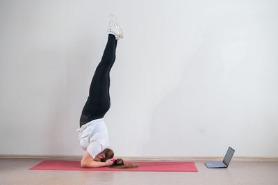 Low section of woman exercising against wall