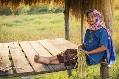 Senior woman sitting in shed at farm