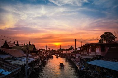 Boats moored at harbor during sunset