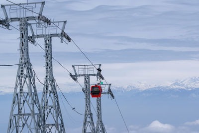 Low angle view of overhead cable car against sky