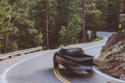 Car on road amidst trees in forest