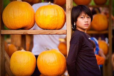 High angle view of girl standing by pumpkin