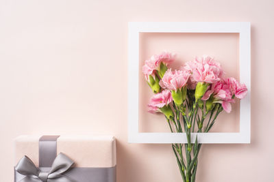 Close-up of pink flower vase against white background