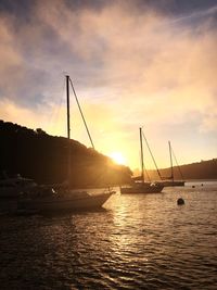 Silhouette sailboats on sea against sky during sunset