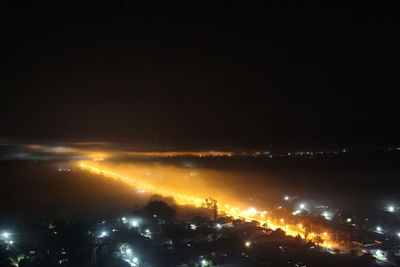 Aerial view of illuminated buildings in city at night