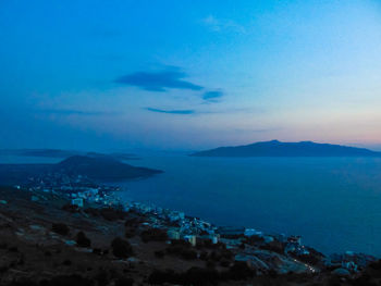 Scenic view of sea and mountains against blue sky