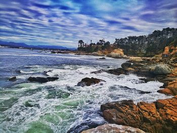 Rocks in sea against sky