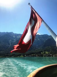 Red flag on boat against sky