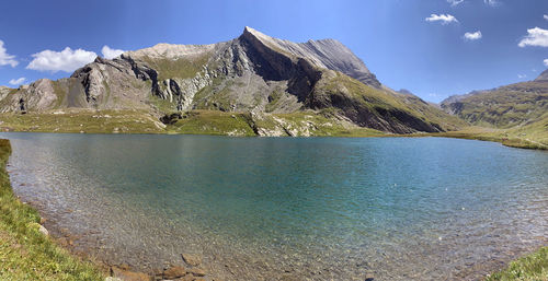 Scenic view of lake by mountain against sky