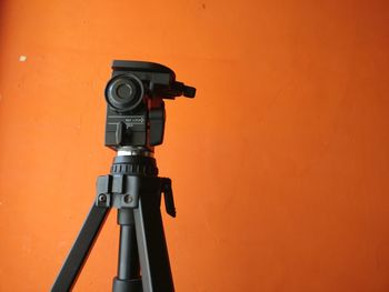 Close-up of camera against orange background