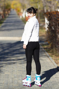 Full length of woman standing on footpath