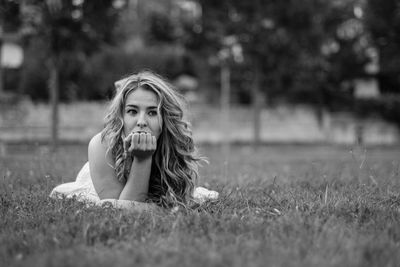 Young woman lying on grassy field