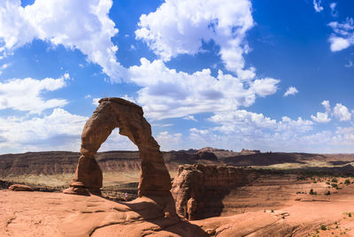 Rock formations on landscape against cloudy sky