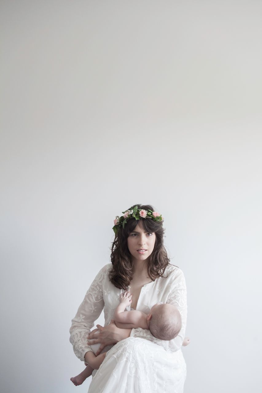 portrait, looking at camera, studio shot, one person, jewelry, adults only, beauty, traditional clothing, white background, only women, bride, adult, people, life events, wedding, young adult, beautiful woman, young women, real people, smiling, wedding dress, one woman only, day, one young woman only, outdoors, tiara