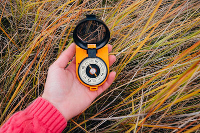 Close-up of hand holding navigational compass