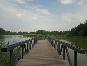 View of bridge over calm lake against sky