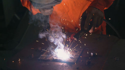 Midsection of man welding metal in workshop