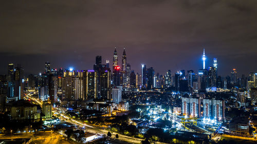 Illuminated cityscape against sky at night