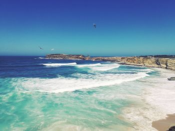 Scenic view of sea against clear blue sky