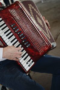 Midsection of man playing accordion in city
