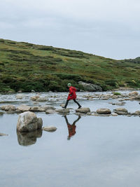 Rear view of woman standing on rocks