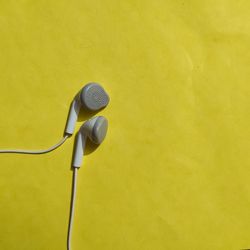 Close-up of electric lamp against yellow wall