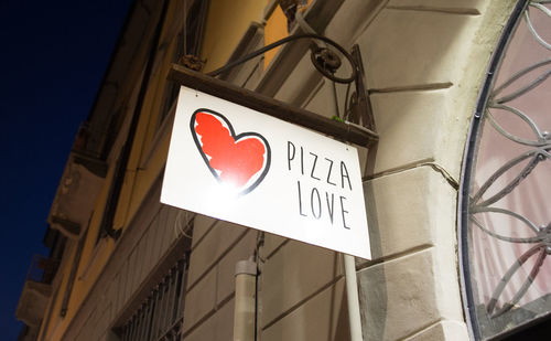 Low angle view of road sign against built structure
