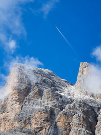 Massive dolomitic rocks with commercial airplane flying over them