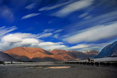 Scenic view of beach and mountains against sky