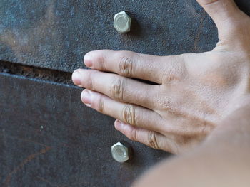 Cropped image of hand touching metal