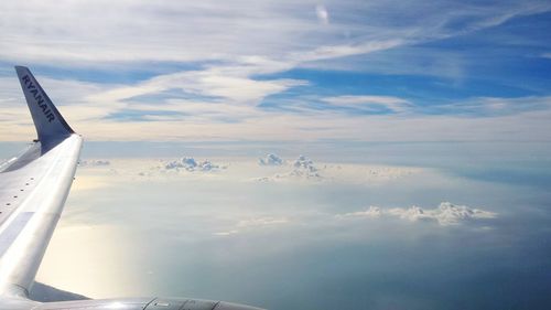 Airplane wing on cloudy sky