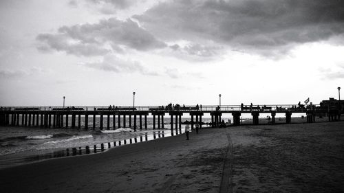 Pier on beach against sky