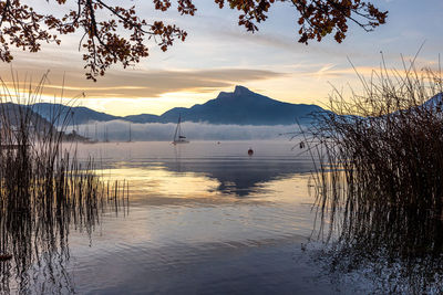 Scenic view of lake against sky at sunset