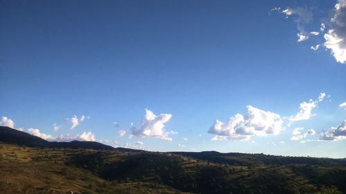 Panoramic view of landscape against blue sky