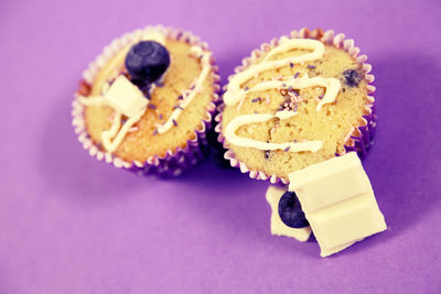 Close-up of cup cakes over purple background