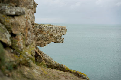 Rock formations by sea against sky