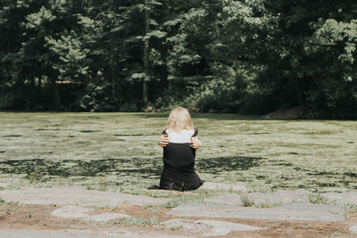 Rear view of woman sitting on swamp