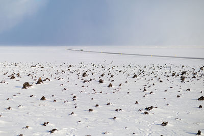 Volcanic rock covered in snow with road in background 