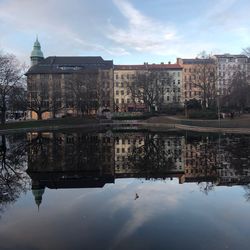 Reflection of buildings in lake against sky