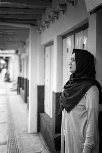 Portrait of teenage girl standing against building