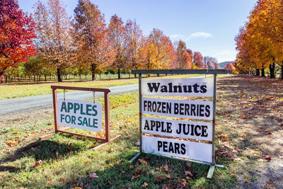 Information sign on field against trees during autumn