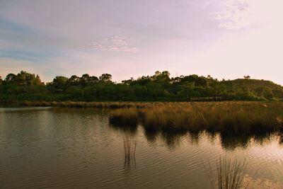 Scenic view of lake against sky at sunset