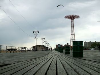 Boardwalk and parachute jump against sky at coney island