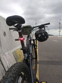 Bicycle parked on road against sky in city