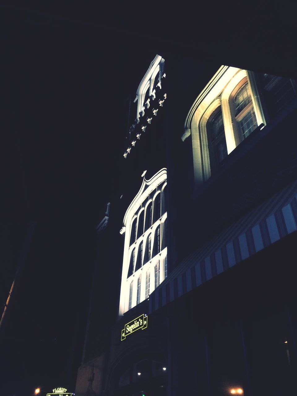 LOW ANGLE VIEW OF BUILDINGS AT NIGHT