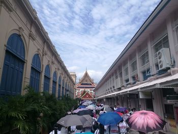 People walking in town square against sky