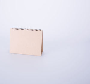 High angle view of blank brown desk calendar on white background