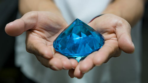 Midsection of person holding gemstone